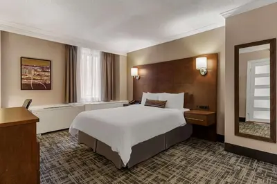 a hotel room with a large bed and a mirror at Best Western Ville-Marie Montreal Hotel & Suites in Montréal