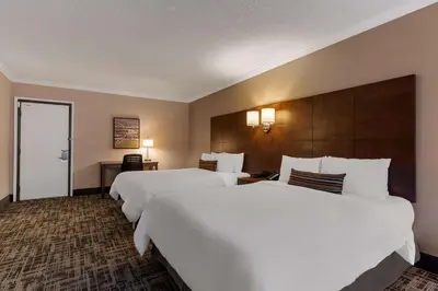 two beds in a hotel room with white sheets at Best Western Ville-Marie Montreal Hotel & Suites in Montréal