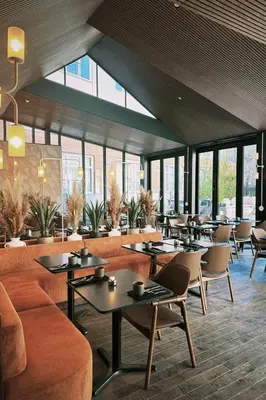 a restaurant with tables and chairs and windows at Hôtel Saint-Sulpice in Montréal