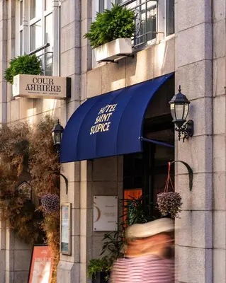 a store with a blue awning on a building at Hôtel Saint-Sulpice in Montréal