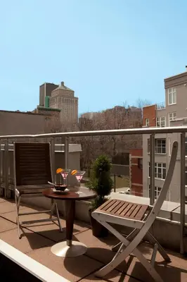 a patio with a table and a chair on a balcony at Hôtel Saint-Sulpice in Montréal