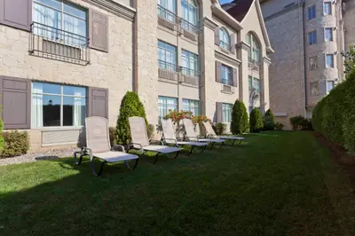a row of chairs sitting in the grass in front of a building at Le St-Martin Hotel & Suites in Laval