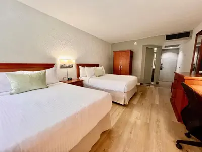 a hotel room with two beds and a television at Hotel Universel Montréal in Montréal