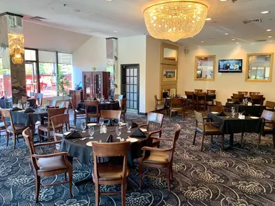 a dining room with tables and chairs and a chandelier at Hotel Universel Montréal in Montréal
