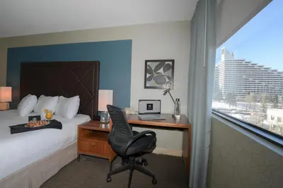 a hotel room with a bed and a desk with a computer at Hotel Universel Montréal in Montréal