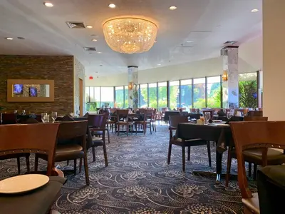 a dining room with tables and chairs and a chandelier at Hotel Universel Montréal in Montréal