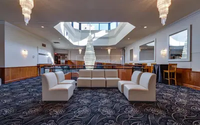 a large waiting room with white chairs and a fountain at Hotel Universel Montréal in Montréal