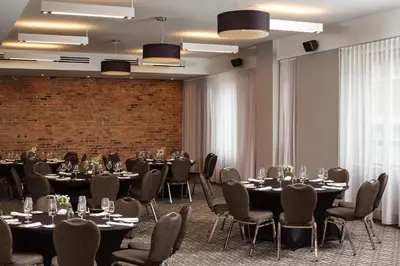 a room with tables and chairs and a brick wall at Hotel Place D'Armes in Montréal
