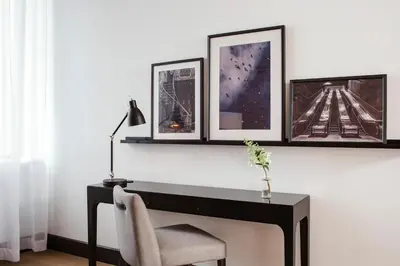 a desk with three pictures on a wall with a chair at Hotel Place D'Armes in Montréal