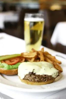 a plate of food with a hamburger and french fries at Hôtel Le Cantlie Suites in Montréal