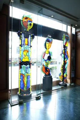 a group of colorful glass sculptures in a display case at Hôtel Le Cantlie Suites in Montréal
