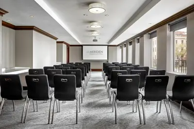 a conference room with chairs and a projection screen at SENS Høtel in Montréal
