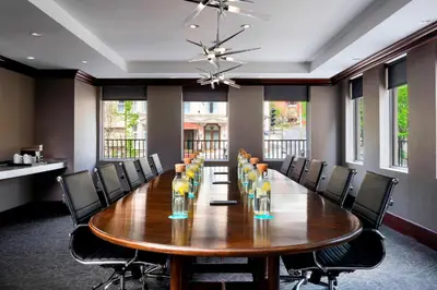 a conference room with a large wooden table and chairs at SENS Høtel in Montréal