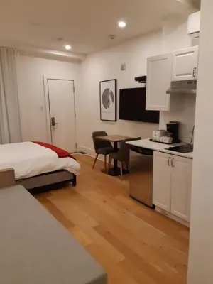 a room with a bed and a kitchen with a table at hotel & spa Carré Saint-Louis in Montréal