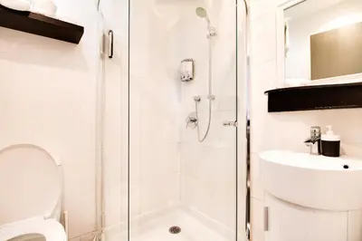 a bathroom with a shower and a toilet and a sink at hotel & spa Carré Saint-Louis in Montréal