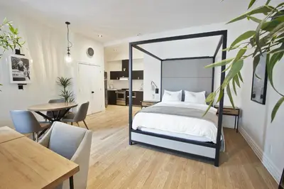 a bedroom with a canopy bed and a dining room at hotel & spa Carré Saint-Louis in Montréal