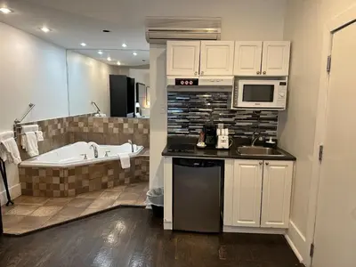 a kitchen with a tub and a sink and a microwave at hotel & spa Carré Saint-Louis in Montréal