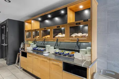 a kitchen with a counter with plates and bread at Best Western Hotel Universel Drummondville in Drummondville