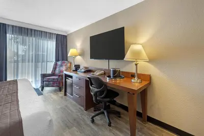 a hotel room with a desk with a bed and a room with a bed at Best Western Hotel Universel Drummondville in Drummondville
