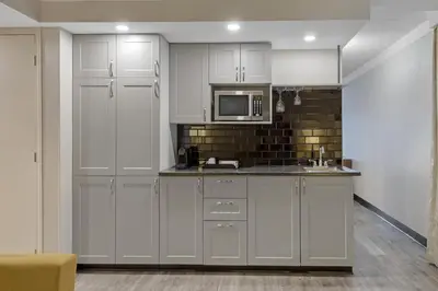 a kitchen with white cabinets and a microwave at Best Western Hotel Universel Drummondville in Drummondville