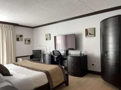 a bedroom with a bed and a desk and a computer at Best Western Hotel Universel Drummondville in Drummondville