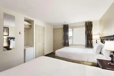 a hotel room with two beds and a window at Days Inn by Wyndham Montreal East in Montréal
