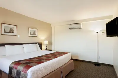 a hotel room with a bed and a tv at Days Inn by Wyndham Montreal East in Montréal
