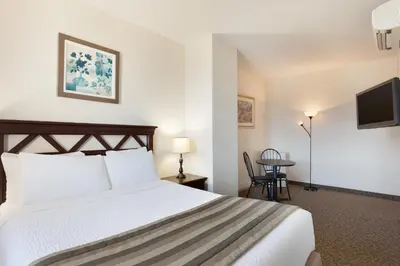 a hotel room with a bed and a table at Days Inn by Wyndham Montreal East in Montréal