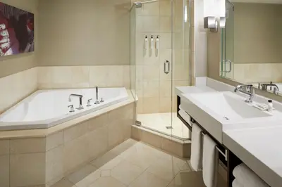 a bathroom with a tub and two sinks and a shower at Delta Hotels by Marriott Montreal in Montréal