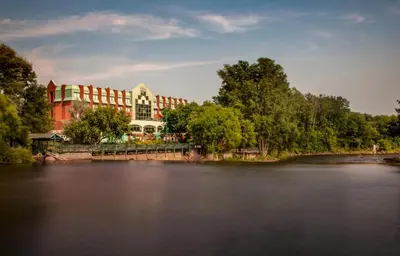 a large building sitting next to a river at Hôtel Château Joliette in Joliette