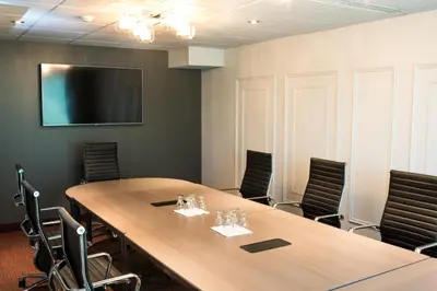 a conference room with a large wooden table and chairs at Hôtel Château Joliette in Joliette