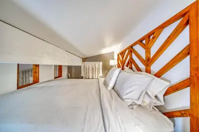 a bedroom with a large bed with a wooden frame at Perfect Loft for a Weekend in the Eastern Townships in Ayer's Cliff