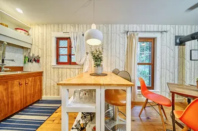 a kitchen with a table and orange chairs at Perfect Loft for a Weekend in the Eastern Townships in Ayer's Cliff