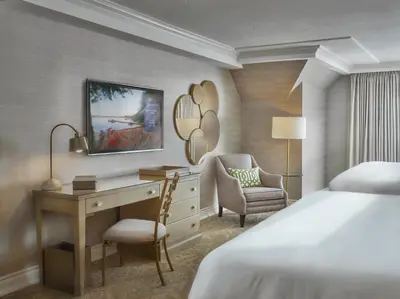 a hotel room with a desk and a bed and a bedroom at Chateau Vaudreuil in Vaudreuil-Dorion