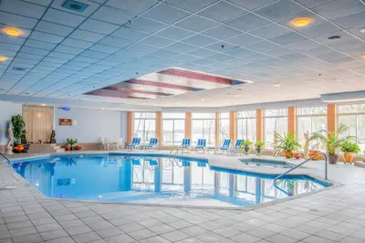 a large swimming pool in a large room with windows at Chateau Vaudreuil in Vaudreuil-Dorion
