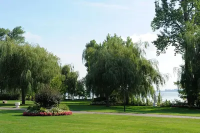 a park with trees and flowers in the grass at Chateau Vaudreuil in Vaudreuil-Dorion