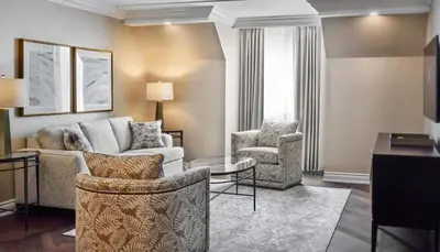 a living room with a couch and two chairs at Chateau Vaudreuil in Vaudreuil-Dorion