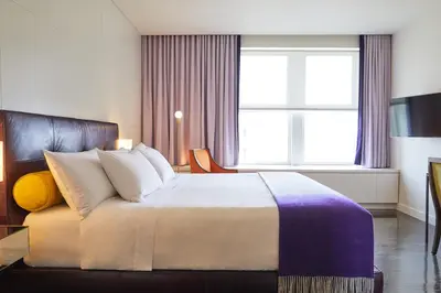 a bedroom with a bed and a large window at Hotel St Paul, Montreal, a Member of Design Hotels in Montréal