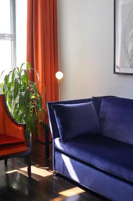 a living room with a blue couch and a plant at Hotel St Paul, Montreal, a Member of Design Hotels in Montréal