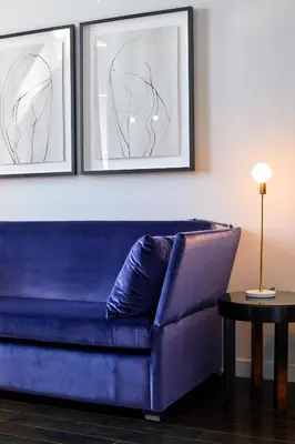 a blue couch in a living room with two framed pictures at Hotel St Paul, Montreal, a Member of Design Hotels in Montréal