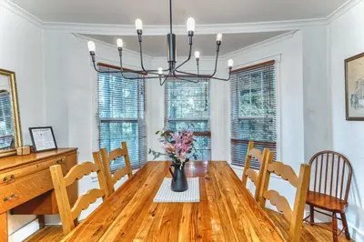 a dining room with a wooden table and a chandelier at Family Winter Home in the Eastern Townships in Ayer's Cliff