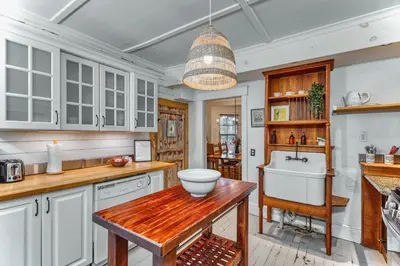 a kitchen with white cabinets and a sink at Family Winter Home in the Eastern Townships in Ayer's Cliff