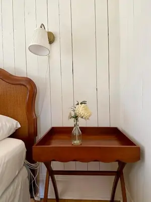 a vase of flowers on a table next to a bed at Family Winter Home in the Eastern Townships in Ayer's Cliff