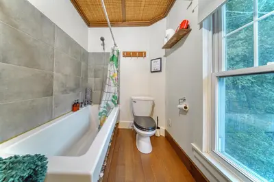 a bathroom with a toilet and a tub and a window at Family Winter Home in the Eastern Townships in Ayer's Cliff