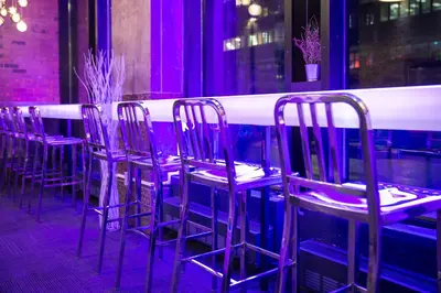 a row of purple chairs in front of a bar at Travelodge by Wyndham Montreal Centre in Montréal