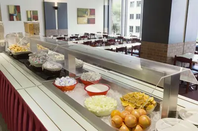 a buffet line with muffins and cupcakes in a cafeteria at Travelodge by Wyndham Montreal Centre in Montréal
