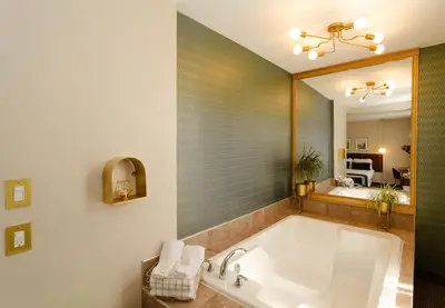 a bathroom with a tub and a large mirror at Hotel Dorion in Montréal