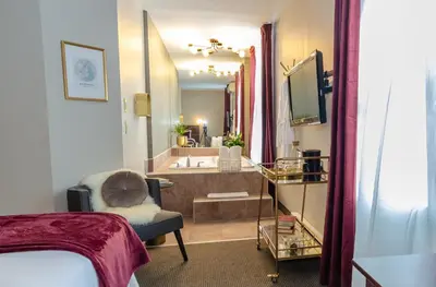 a bedroom with a bathroom with a tub and a sink at Hotel Dorion in Montréal