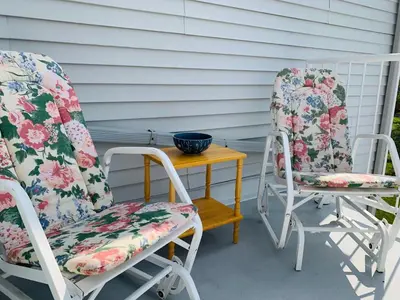 two chairs and a small table on a porch at Le Philémon Club Azur plage Memphrémagog in Magog-Orford