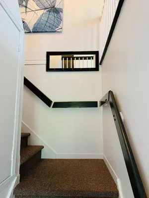 a staircase in a house with a mirror on the wall at Le Philémon Club Azur plage Memphrémagog in Magog-Orford